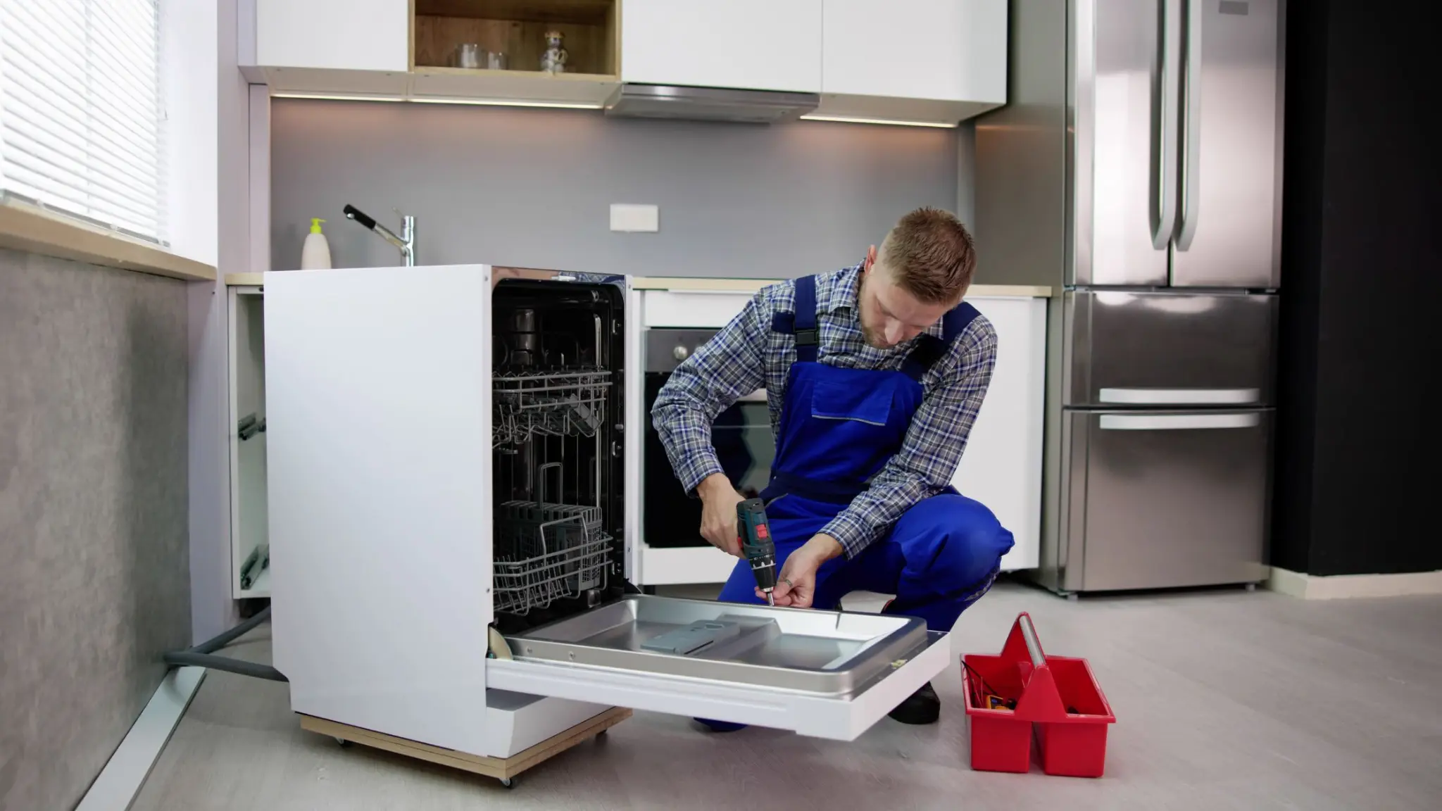 Appliance repair professional working on an open residential dishwasher